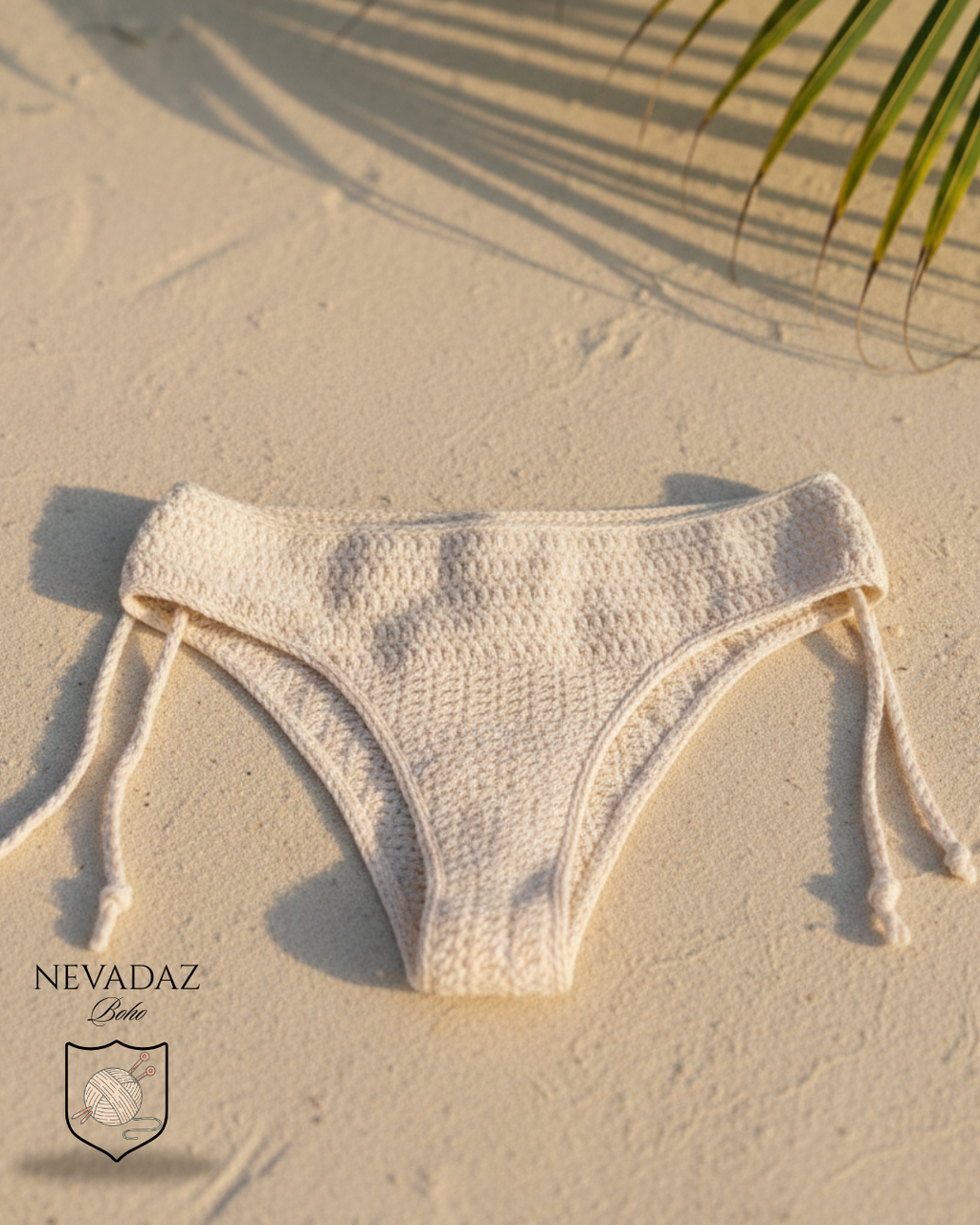 Beige bikini bottom on sand with palm leaf shadow